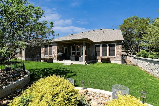603 Archer Ln, Georgetown, TX 78633 - rear view of house with a shingled roof, a patio area, a lawn, a fenced backyard, and brick siding
