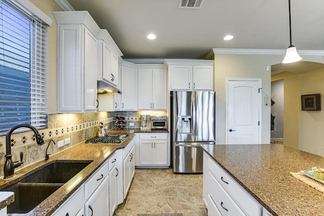 603 Archer Ln, Georgetown, TX 78633 - kitchen featuring ornamental molding, stainless steel refrigerator with ice dispenser, dark stone countertops, under cabinet range hood, and a sink