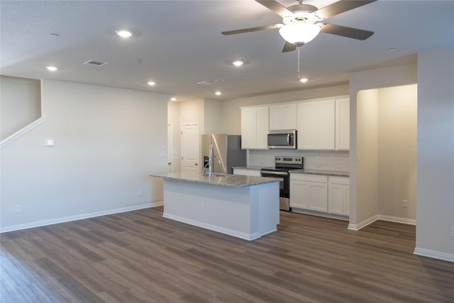 1850 Settlers Glen Dr Unit 904, Round Rock, TX 78665 - kitchen with baseboards, a kitchen island with sink, white cabinetry, stainless steel appliances, and dark wood-type flooring