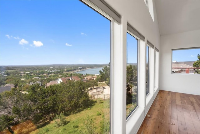 403 Rogart Dr, Spicewood, TX 78669 - unfurnished sunroom featuring a water view, wood-type flooring, and a towering ceiling