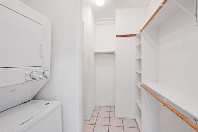 403 Rogart Dr, Spicewood, TX 78669 - laundry room with light tile patterned floors, stacked washer and dryer, and laundry area