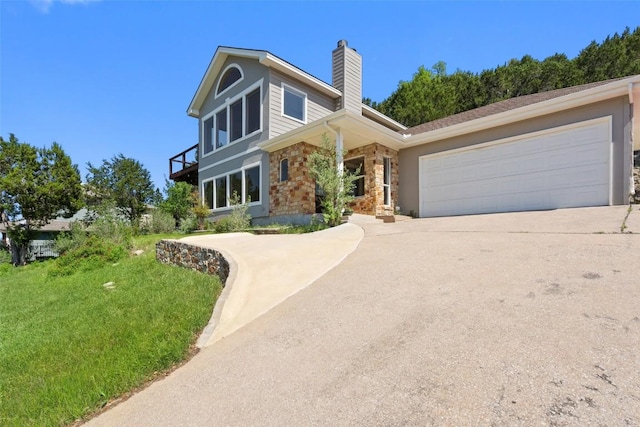 403 Rogart Dr, Spicewood, TX 78669 - view of front of property with an attached garage, driveway, a chimney, and stone siding