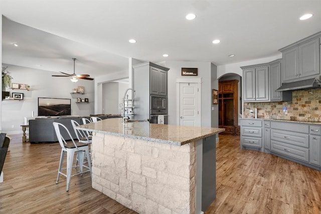 617 Chama Trce, Dripping Springs, TX 78620 - kitchen featuring gray cabinetry, under cabinet range hood, arched walkways, a ceiling fan, and stainless steel microwave