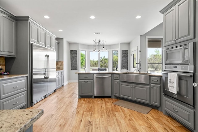 617 Chama Trce, Dripping Springs, TX 78620 - kitchen with gray cabinetry, built in appliances, recessed lighting, light wood finished floors, and a sink