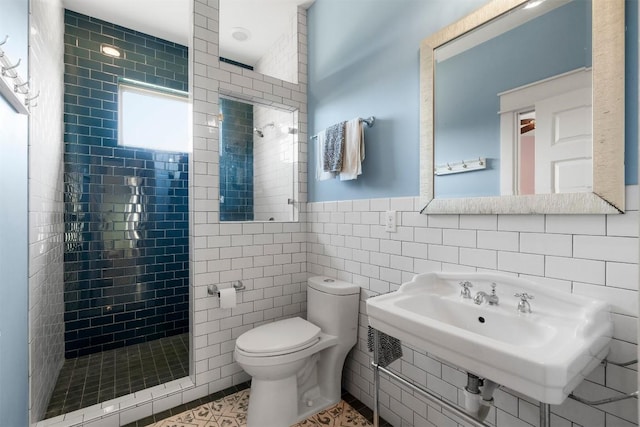 617 Chama Trce, Dripping Springs, TX 78620 - bathroom featuring tile walls, a stall shower, toilet, a sink, and tile patterned floors
