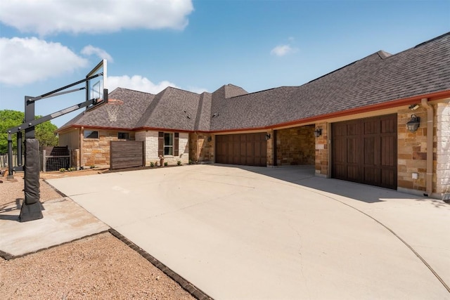 617 Chama Trce, Dripping Springs, TX 78620 - view of front of home with stone siding, driveway, a garage, and roof with shingles