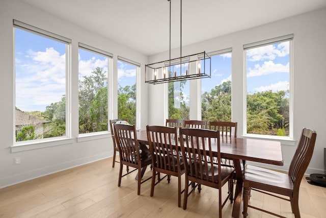 6701 Adventures Pl, Jonestown, TX 78645 - dining room featuring baseboards, a wealth of natural light, a notable chandelier, and light wood finished floors