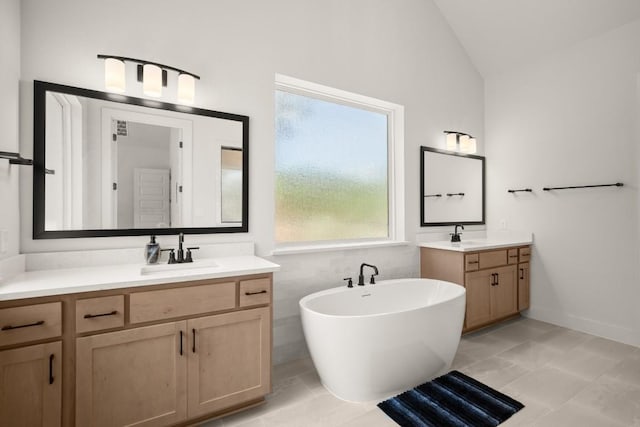 6701 Adventures Pl, Jonestown, TX 78645 - bathroom featuring a sink, a freestanding bath, lofted ceiling, and two vanities