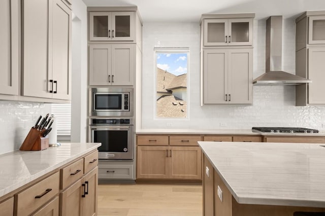 6701 Adventures Pl, Jonestown, TX 78645 - kitchen featuring wall chimney range hood, light wood-type flooring, stainless steel appliances, and backsplash