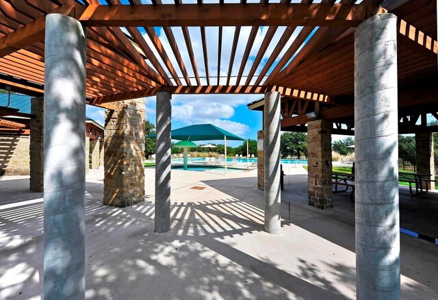 view of patio featuring a community pool and a pergola