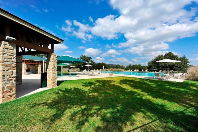 view of yard with a community pool and a patio area