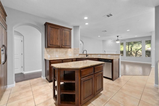 4014 Remington Rd, Cedar Park, TX 78613 - kitchen featuring dishwasher, arched walkways, a sink, a peninsula, and light tile patterned flooring