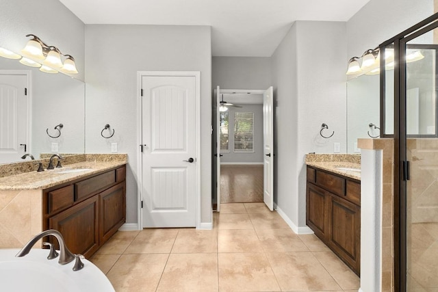 4014 Remington Rd, Cedar Park, TX 78613 - full bath with two vanities, a stall shower, tile patterned floors, a bathtub, and baseboards