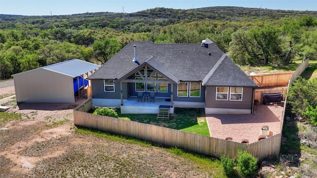 283 Calle Cortez Dr, Buchanan Dam, TX 78609 - back of property with a patio area, fence private yard, a view of trees, and a shingled roof