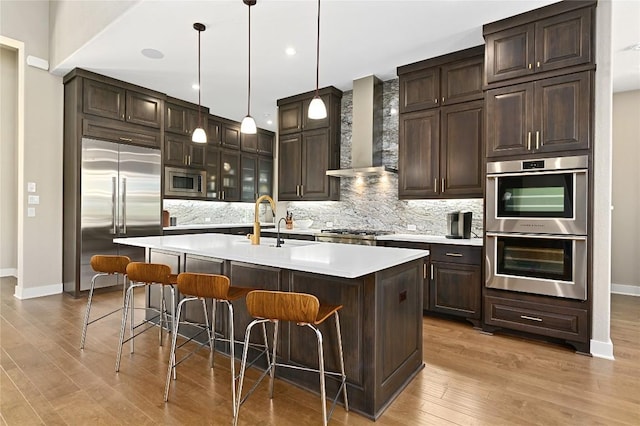 607 Flint Ridge Trl, Georgetown, TX 78628 - kitchen featuring wall chimney range hood, baseboards, built in appliances, and decorative backsplash