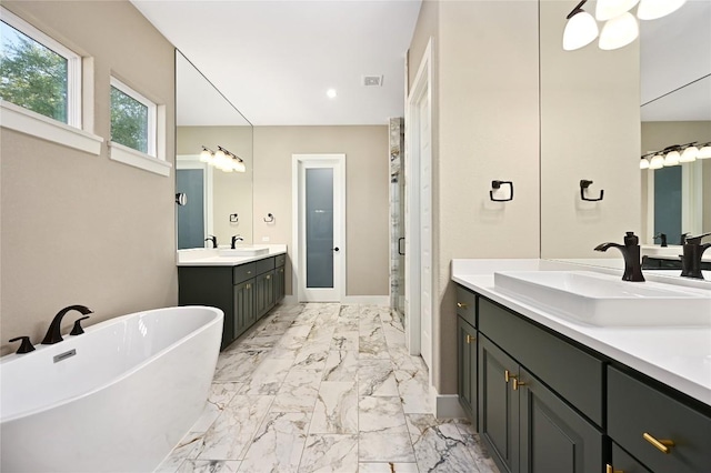 607 Flint Ridge Trl, Georgetown, TX 78628 - bathroom with marble finish flooring, two vanities, a freestanding bath, recessed lighting, and a stall shower