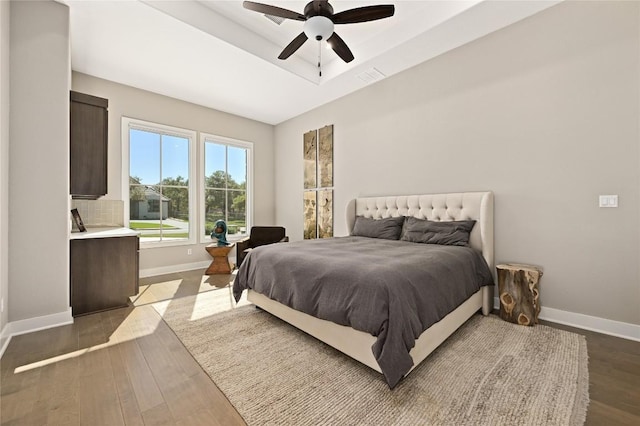 607 Flint Ridge Trl, Georgetown, TX 78628 - bedroom featuring visible vents, baseboards, dark wood-style flooring, ceiling fan, and a tray ceiling