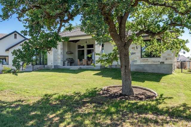 607 Flint Ridge Trl, Georgetown, TX 78628 - rear view of house featuring stone siding, fence, a yard, and stucco siding