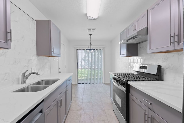 11500 Ruffed Grouse Dr, Austin, TX 78758 - kitchen featuring stainless steel appliances, gray cabinetry, a sink, under cabinet range hood, and tasteful backsplash