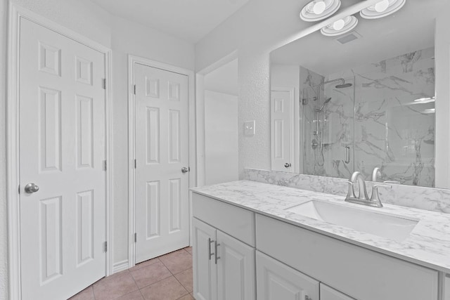 11500 Ruffed Grouse Dr, Austin, TX 78758 - bathroom featuring a marble finish shower, tile patterned flooring, and vanity
