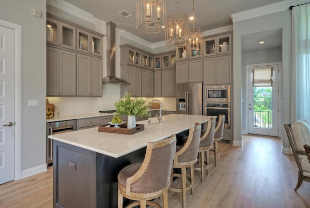 kitchen with visible vents, wall chimney exhaust hood, appliances with stainless steel finishes, wine cooler, and gray cabinets
