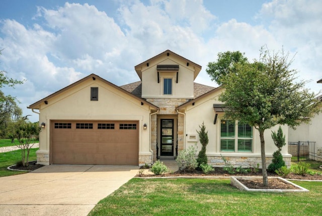 view of front of home featuring driveway, stone siding, an attached garage, and a front lawn