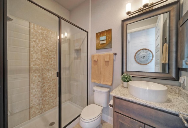 bathroom featuring toilet, a stall shower, and vanity
