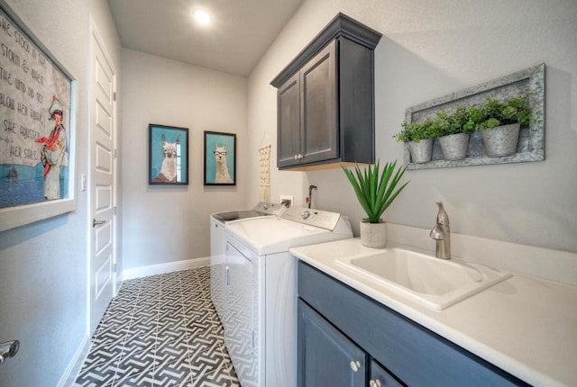 laundry room featuring a sink, washing machine and clothes dryer, baseboards, and cabinet space