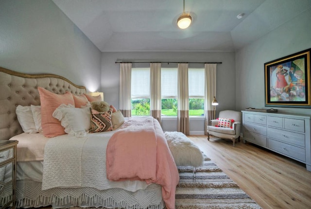 bedroom featuring light wood-style floors and lofted ceiling