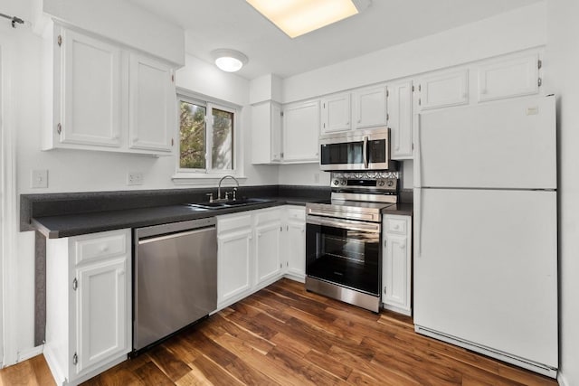21459 Coyote Trl Unit B4, Lago Vista, TX 78645 - kitchen featuring appliances with stainless steel finishes, dark countertops, and white cabinets