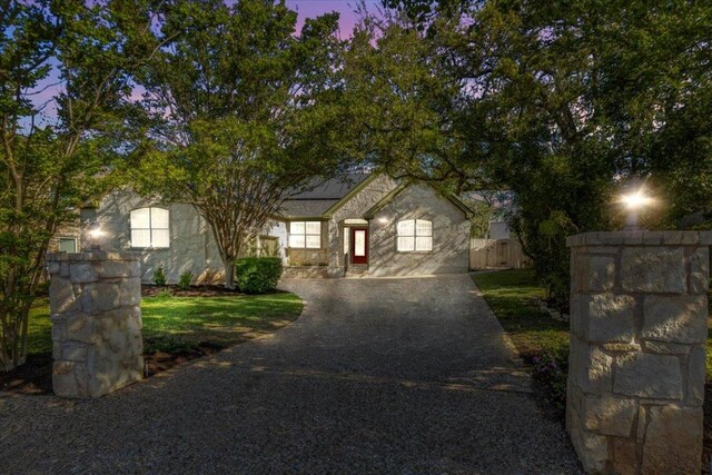 8312 Jancy Dr, Austin, TX 78750 - view of front of property with asphalt driveway, roof mounted solar panels, and stone siding
