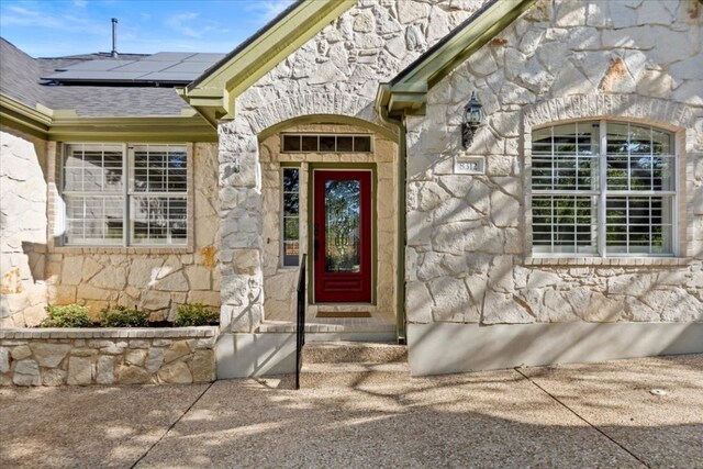 8312 Jancy Dr, Austin, TX 78750 - doorway to property featuring stone siding and solar panels