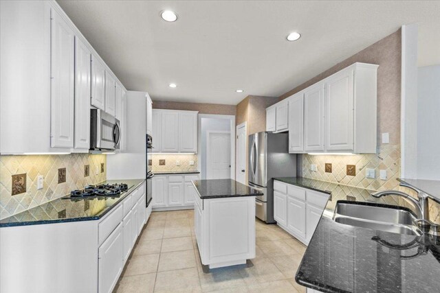 8312 Jancy Dr, Austin, TX 78750 - kitchen featuring appliances with stainless steel finishes, a kitchen island, backsplash, white cabinets, and recessed lighting
