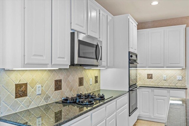 8312 Jancy Dr, Austin, TX 78750 - kitchen featuring stainless steel microwave, gas cooktop, white cabinets, decorative backsplash, and recessed lighting
