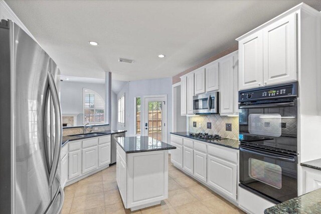8312 Jancy Dr, Austin, TX 78750 - kitchen with appliances with stainless steel finishes, decorative backsplash, white cabinets, recessed lighting, and a kitchen island
