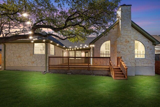 8312 Jancy Dr, Austin, TX 78750 - back of house with stone siding, a deck, a lawn, and a chimney