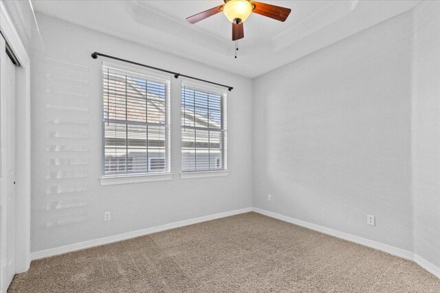 8312 Jancy Dr, Austin, TX 78750 - unfurnished bedroom featuring carpet flooring, a tray ceiling, a closet, ornamental molding, and ceiling fan