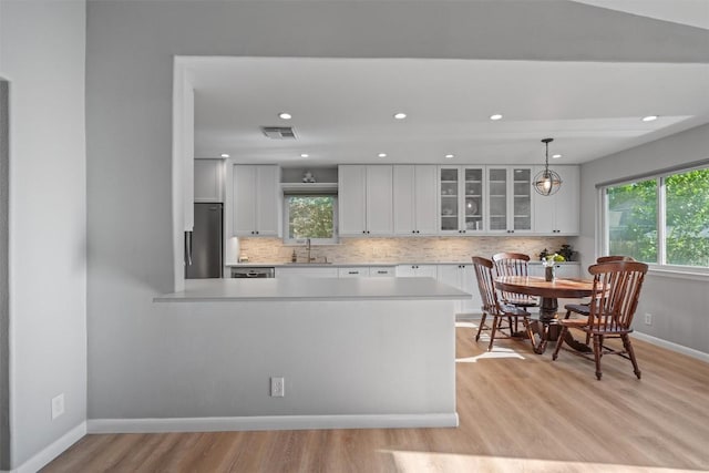 11605 Gunsmoke Cir, Austin, TX 78750 - kitchen with a sink, appliances with stainless steel finishes, light countertops, light wood finished floors, and backsplash