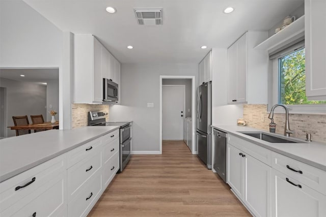 11605 Gunsmoke Cir, Austin, TX 78750 - kitchen featuring appliances with stainless steel finishes, a sink, tasteful backsplash, white cabinets, and recessed lighting