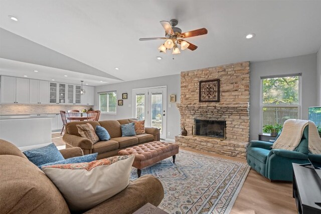 11605 Gunsmoke Cir, Austin, TX 78750 - living area with a ceiling fan, light wood-style flooring, vaulted ceiling, a stone fireplace, and recessed lighting