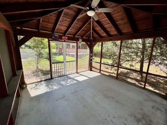 unfurnished sunroom with a ceiling fan and beam ceiling