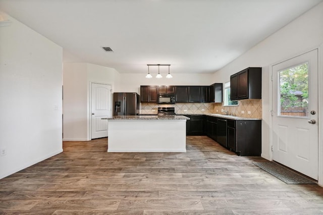 234 Coleto Creek Loop, Kyle, TX 78640 - kitchen with stainless steel fridge, black microwave, stove, backsplash, and dishwashing machine