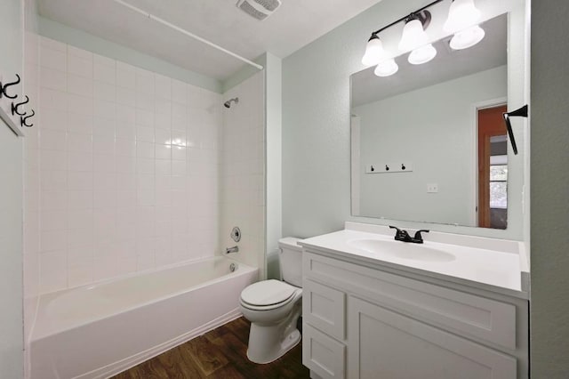 234 Coleto Creek Loop, Kyle, TX 78640 - bathroom featuring toilet, wood finished floors, vanity, and shower / washtub combination