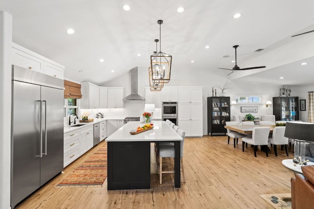 1001 Lakeshore Dr, Marble Falls, TX 78654 - kitchen featuring open floor plan, light countertops, wall chimney exhaust hood, appliances with stainless steel finishes, and a sink
