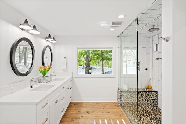 1001 Lakeshore Dr, Marble Falls, TX 78654 - bathroom featuring wood finished floors, a sink, visible vents, and tiled shower