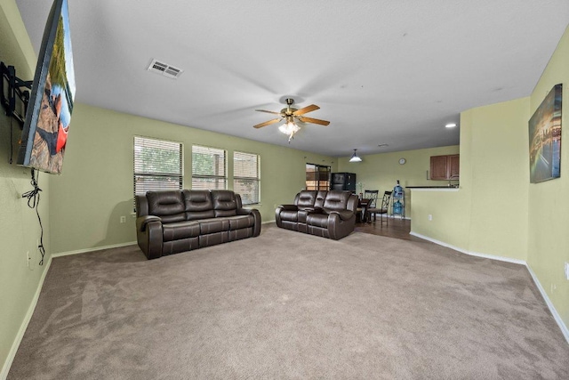 living room featuring a ceiling fan, carpet floors, and baseboards