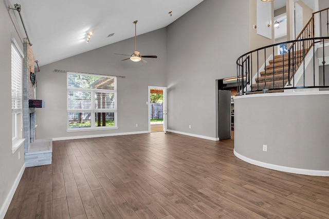 15811 De Peer Cv, Austin, TX 78717 - unfurnished living room featuring a ceiling fan, wood finished floors, stairway, and high vaulted ceiling
