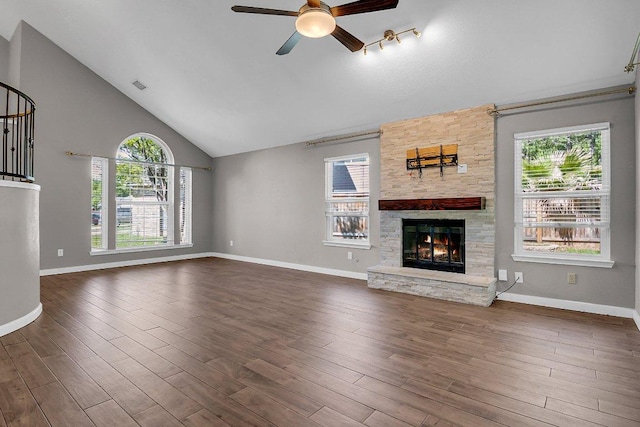 15811 De Peer Cv, Austin, TX 78717 - unfurnished living room featuring a stone fireplace, a ceiling fan, dark wood-type flooring, high vaulted ceiling, and stairs