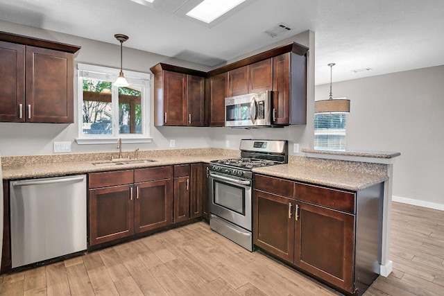 15811 De Peer Cv, Austin, TX 78717 - kitchen with stainless steel appliances, light wood-style flooring, a peninsula, and plenty of natural light