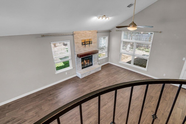 15811 De Peer Cv, Austin, TX 78717 - unfurnished living room with vaulted ceiling, a fireplace, wood finished floors, and a ceiling fan